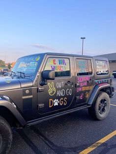 a jeep parked in a parking lot with writing on the side of it's door