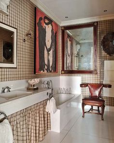 a bathroom with two sinks, a tub and a chair