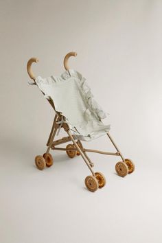 a baby's buggy with wooden wheels and an umbrella on the top, in front of a white background