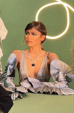 a mannequin sitting on top of a table in front of a neon sign