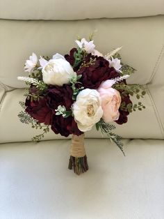 a bridal bouquet sitting on top of a couch