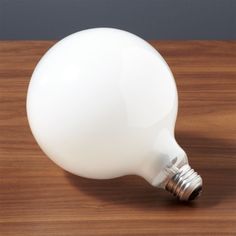 a white light bulb sitting on top of a wooden table