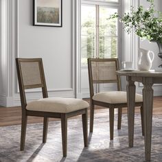 a dining room table with chairs and a vase on it