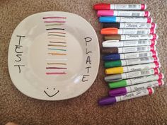 a plate with markers and crayons sitting on the floor next to each other