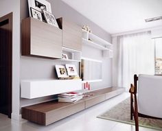 a modern living room with white walls and wooden furniture on the shelves, along with a dining table