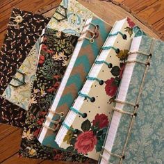 several notebooks lined up on top of each other in different colors and patterns,