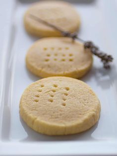 three cookies on a plate with a pair of scissors