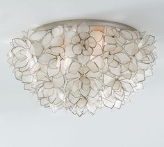 a light fixture with white flowers on it