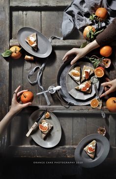 people are eating oranges and other food on plates