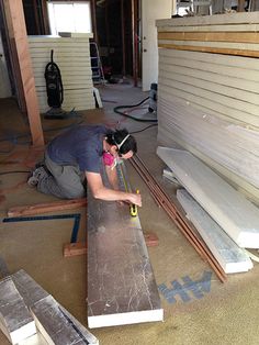 a woman is working on some boards in a room