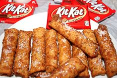 a white plate topped with lots of doughnuts next to two packs of kitkat