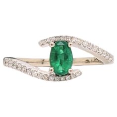 This beautiful bypass ring features a vibrant green emerald in solid 14k gold with a pave diamond band. A dainty ring design perfect for an eye catching engagement or anniversary. This ring also makes a beautiful May birthstone ring for your loved ones! Specifications Item Type: Ring Center Stone: Emerald Treatment: Oiled Weight: 0.4ct Head size: 6x4mm Shape: Oval Hardness: 7.5-8 Metal: 14k/2.82g Diamond Clarity/Color: SI / G-H Diamond Count/Weight: 30/0.15 cttw SKU: AJR430/1670 This ring is made with solid 14K Gold and natural Earth mined SI / G-H diamonds. As listed, this ring is ready to ship. If you're interested in purchasing this setting with a different center stone please message us! Ceylon Sapphire Ring, May Birthstone Rings, Green Tourmaline Ring, Pave Diamond Band, Art Deco Wedding Rings, Pink Tourmaline Ring, Bypass Ring, Modern Ring, Tourmaline Ring