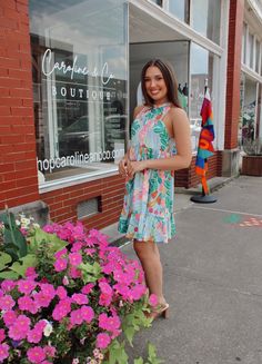 This cute ruffled mini dress will set off a fashion trend and have you feeling totally refreshed. We love its sleeveless, frilled mock neck with a lace-up design at the back, and the high-quality fabric. Its pretty floral print is one of the most popular fashion elements at the moment. This dress looks good with sandals, high heels, or flats. This will be your go-to dress of the summer. 90% Polyester, 10% Elastane. Sizing runs true. Model is wearing a size small. Day Out Ruffled Halter Sundress, Casual Sleeveless Mini Dress For Garden Party, Feminine Sleeveless Mini Dress For Vacation, Ruffled Halter Sundress For Day Out, Trendy Sleeveless Mini Dress For Garden Party, Halter Neck Mini Dress With Ruffle Hem For Brunch, Spring Vacation Halter Dress With Ruffles, Casual Sleeveless Dress With Ruffle Hem For Spring, Sleeveless Ruffled Halter Dress For Day Out