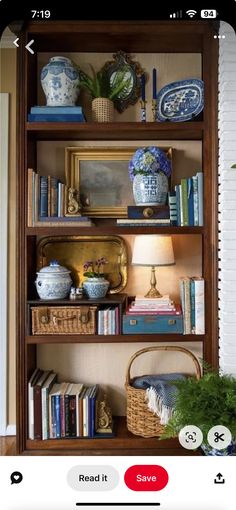 a book shelf filled with books next to a lamp and potted plant on top of it