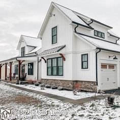 a white house with two garages and snow on the ground