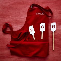 a red apron and spatulas with the word chuck on them sitting next to each other