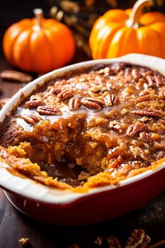 a close up of a pie in a pan on a table with pumpkins behind it