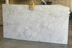 a large white marble counter top in a warehouse or office building with yellow hardware on it