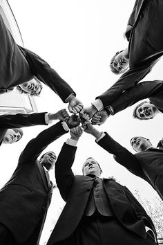 a group of people standing in a circle with their hands on top of each other