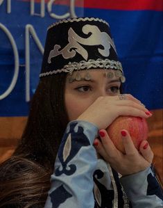 a woman holding an apple in front of her face