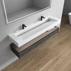 two white sinks sitting on top of a wooden floor next to a large mirror above them