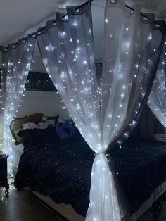 a canopy bed with white lights on it