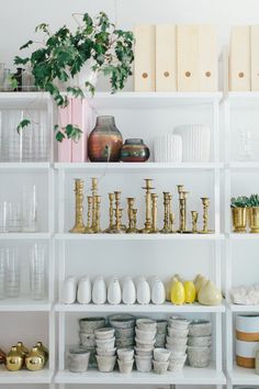 the shelves are filled with vases, bowls and other decorative items in white shelving