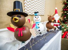 three snowmen and two turkeys are sitting on a table