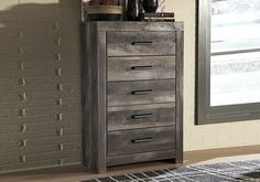 a tall chest of drawers in front of a window with bottles and wine glasses on top