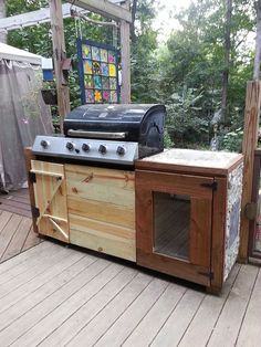 an outdoor kitchen made out of pallets and wood with a grill on the top