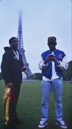 two men standing in front of the eiffel tower