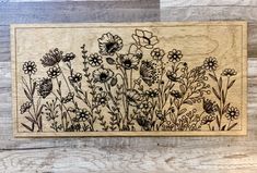 a wooden plaque with flowers engraved on it