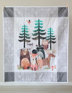 a wall hanging with animals and trees on it