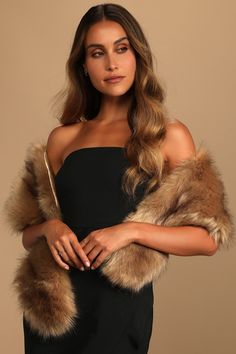 a woman wearing a black dress and fur stole