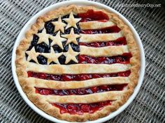 an american flag pie in a white bowl on a gray tablecloth with the stars and stripes painted on it