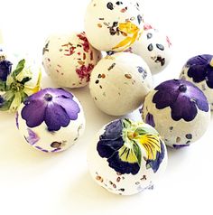 painted eggs with flowers on them sitting next to each other