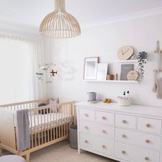 a baby's room with a crib and dresser