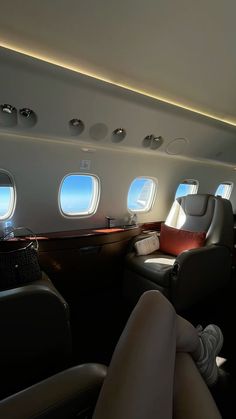 a woman sitting on an airplane with her feet up in the air