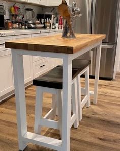 a kitchen island with two stools in front of it