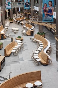 the inside of a building with tables and benches on each side of the walkways