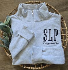 This cute SLP quarter zip sweatshirt makes a perfect SLP gift. It is a wonderful gift, but this Speech Language Pathologist sweater makes a great staple for your own wardrobe. It is a perfect SLP shirt for the workplace, daily life, and for gifting to others, such as a therapy team, graduation gift, or appreciation gift! *Unisex sizing. No pockets. 1/4 Zip. Embroidery is on left chest, unless requested otherwise. *Unisex sizing. No pockets. 1/4 Zip. Embroidery is on left chest, unless requested otherwise. 8 oz./yd², 13.36 oz L yd (CA). All sweatshirts except oxford color are 50% cotton 50% polyester. Oxford is 48% cotton 52 % polyester. Pre-shrunk material. I recommend ordering your typical shirt size.  To order: 1.  Shirt Color 2. Shirt Size In personalization box: 1. Enter thread color + Slp Shirts, Speech Language Pathologist, Speech Language Pathology, Speech Language Pathologists, Black Thread, Quarter Zip Sweatshirt, Crafting Ideas, Sweater Making, Speech And Language