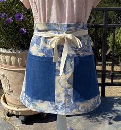 a woman wearing an apron with blue flowers on it