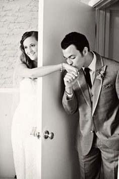 a man and woman standing next to each other in front of a wall with writing on it