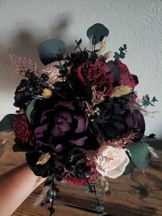 a bouquet of flowers sitting on top of a wooden table