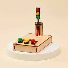 a wooden toy with traffic lights and cars on it