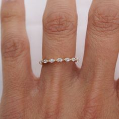 a woman's hand with a wedding ring on it, showing the diamond band