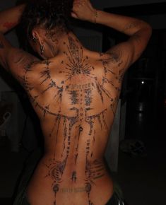 the back of a woman with tattoos on her body