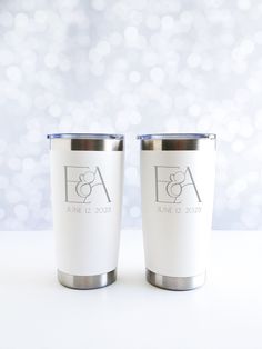 two white tumblers sitting next to each other on a table