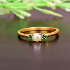 a close up of a ring on a table with flowers in the background and green leaves