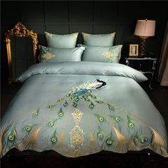 a peacock themed bed in a dark room with two lamps on either side of the bed